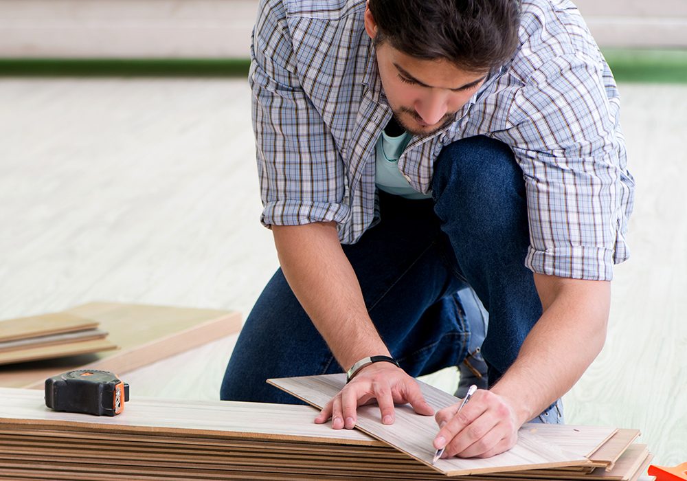 Man laying flooring at home The man laying flooring at home